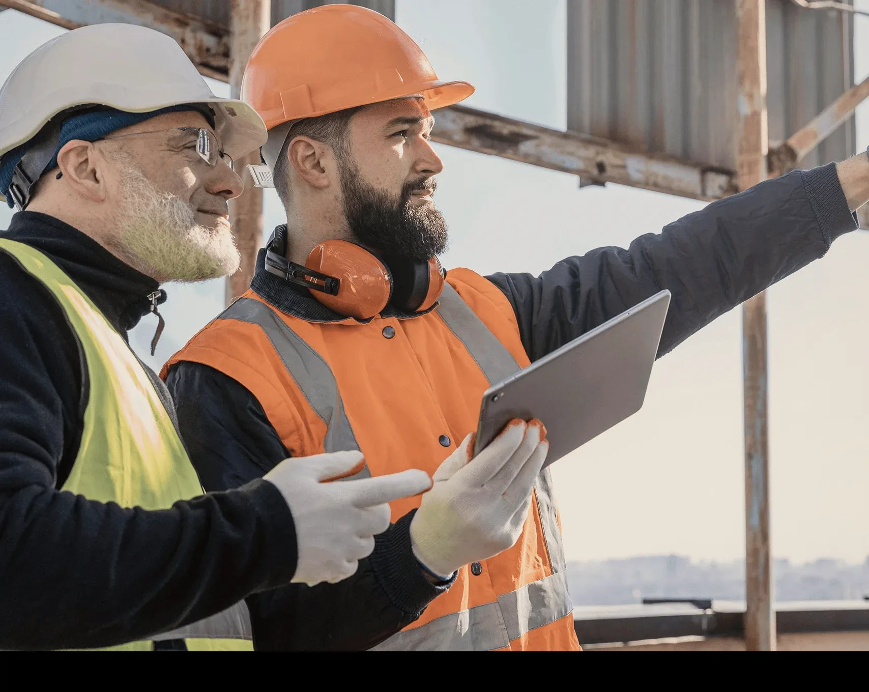 Two workers in high-visibility jackets with a tablet.