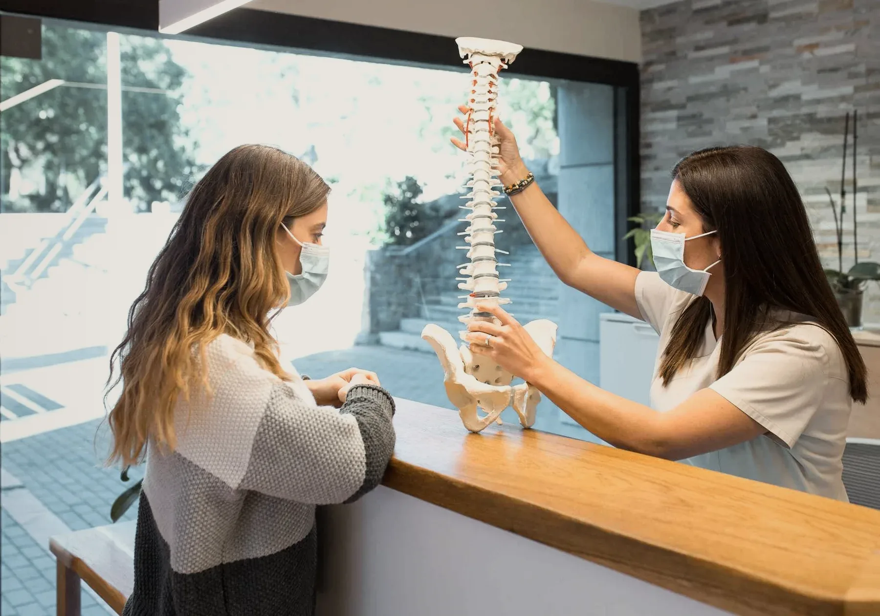 A physiotherapist pointing at a spine chart.