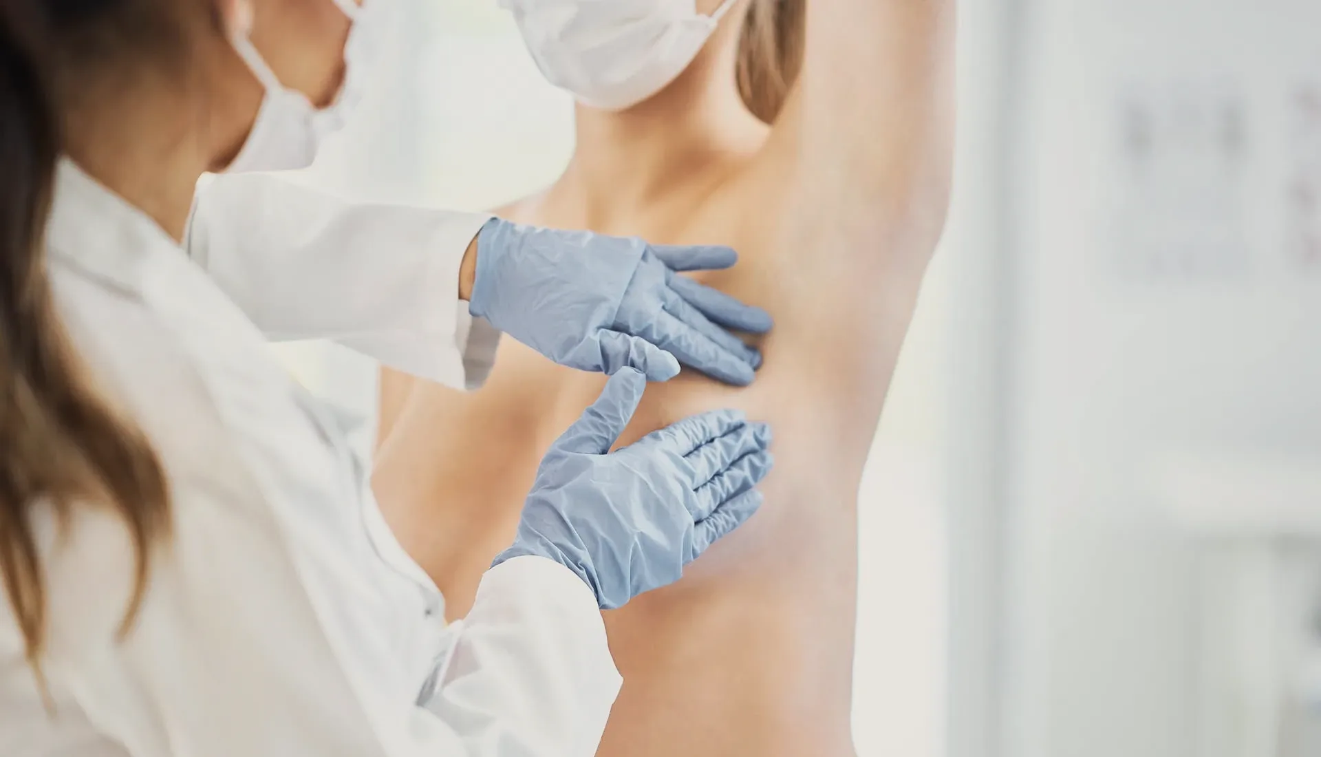 A patient examined by a doctor in blue gloves.