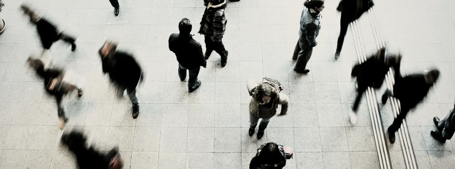 A crowd crossing a plaza, seen from above.