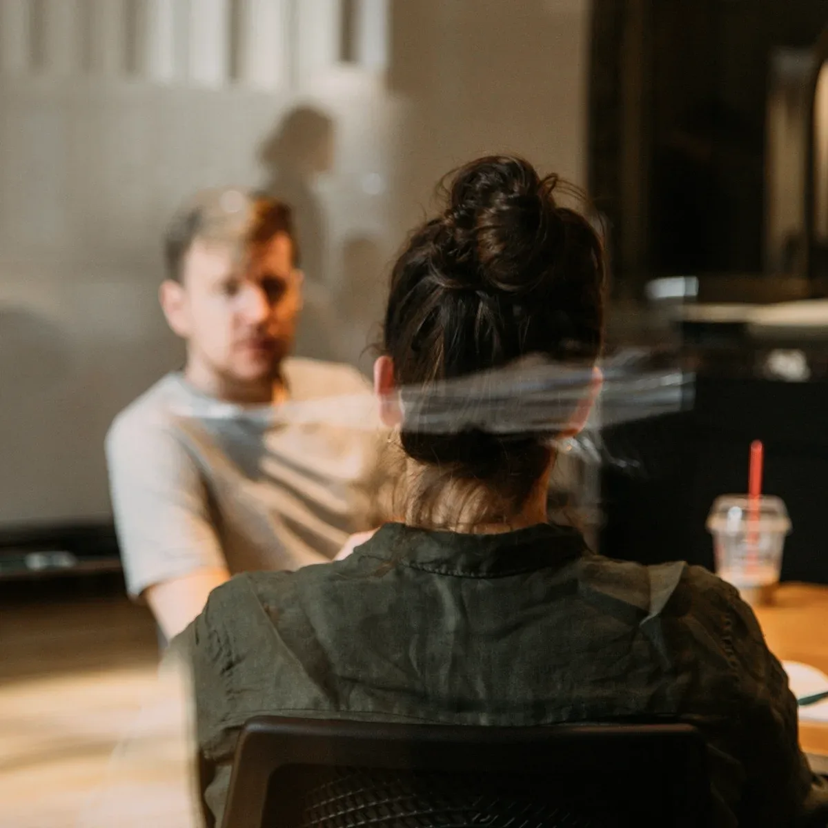A woman seen from behind in a meeting.