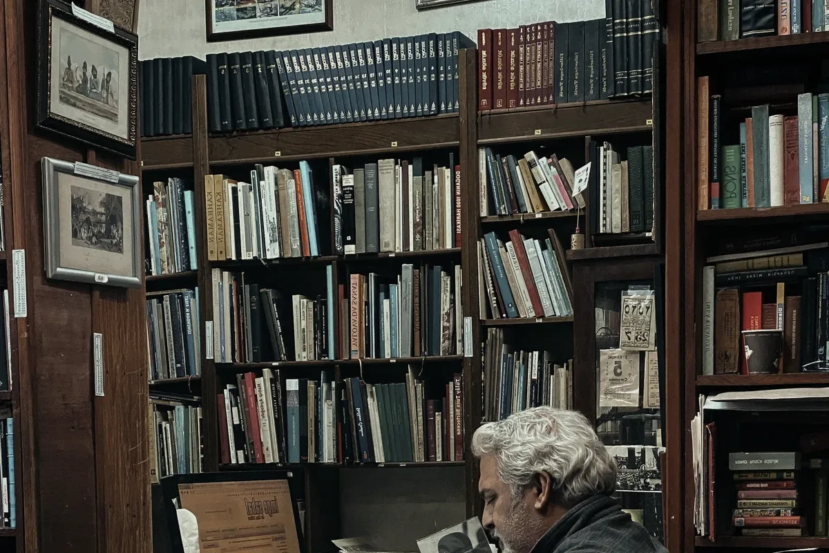 A man at a desk among books.