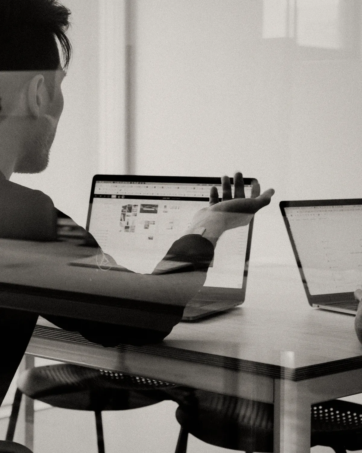 A man at a laptop in a dark room.