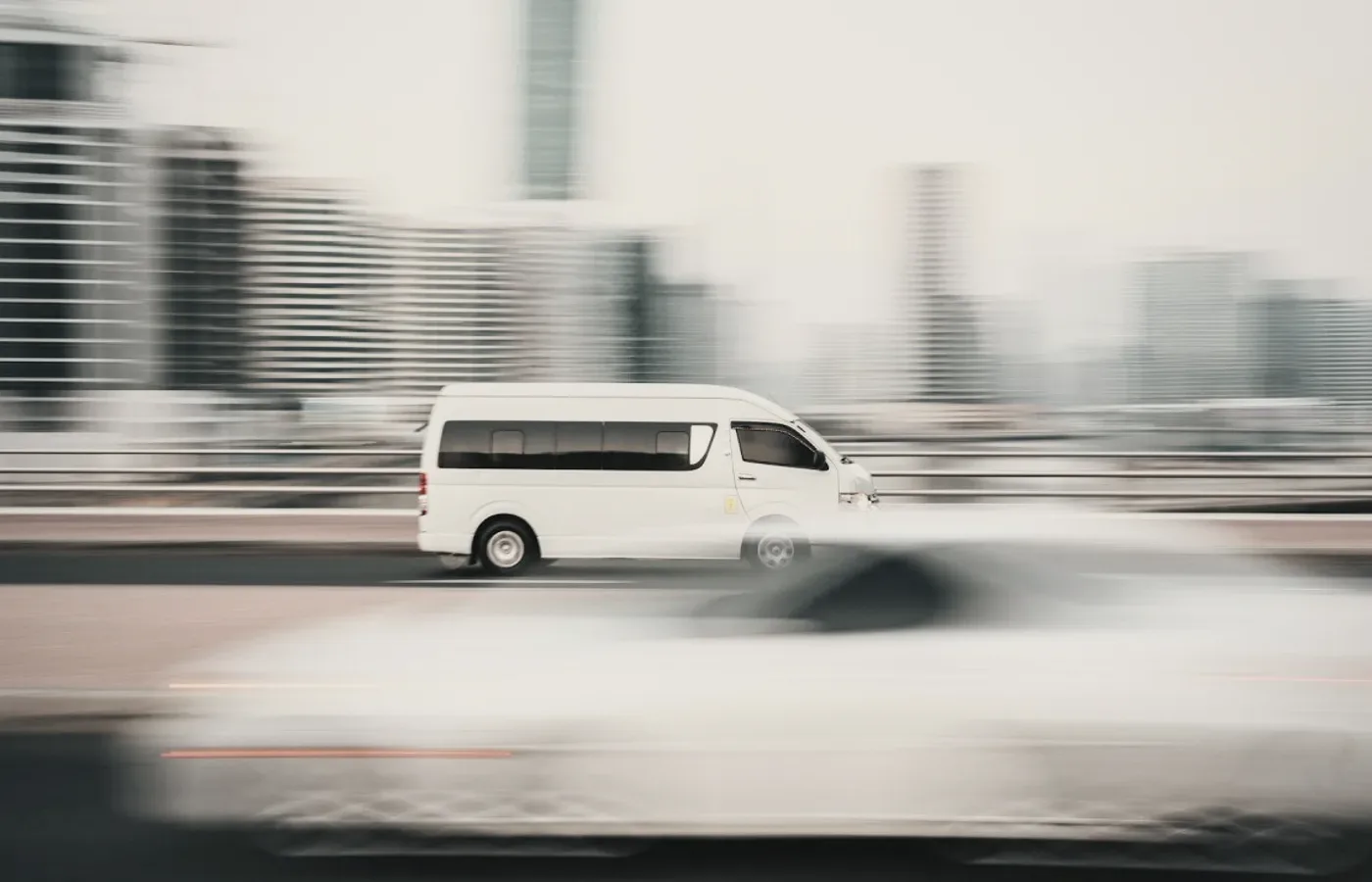 A white van in motion through a city.
