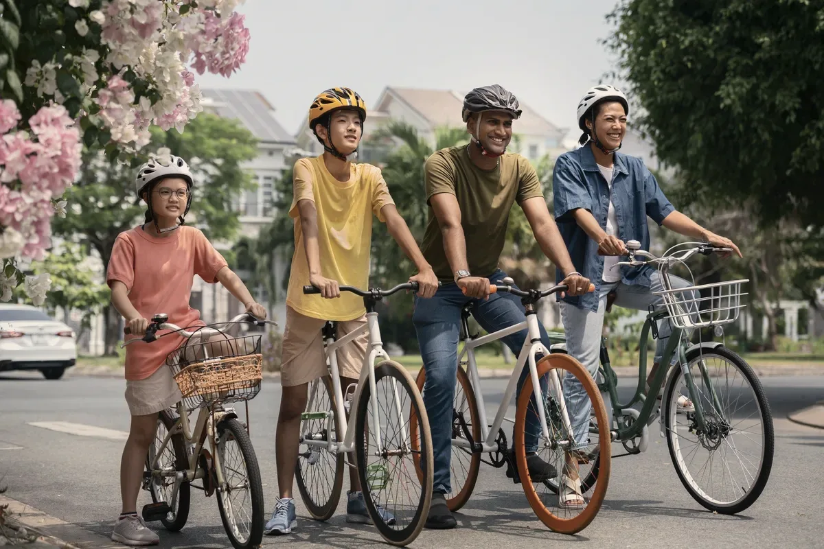 Four cyclists on a tree-lined street.