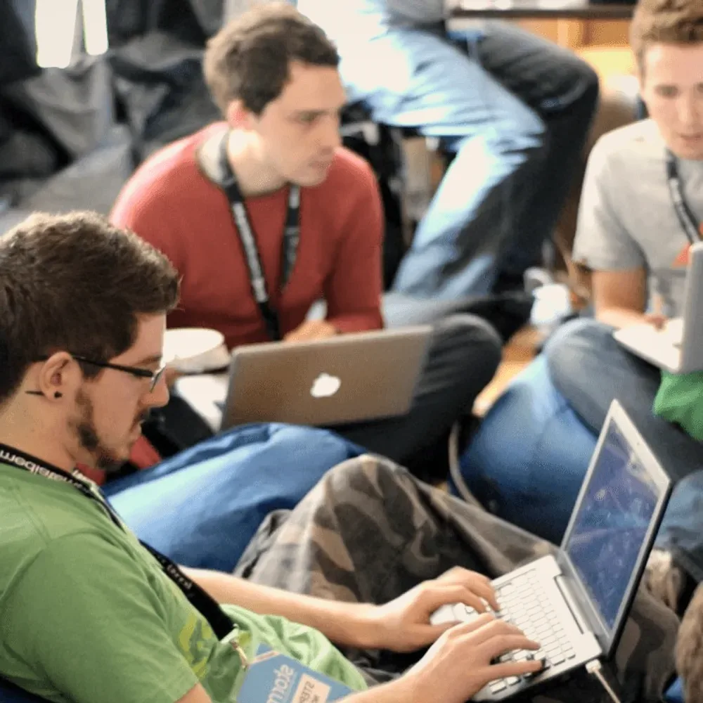Students on bean bags with laptops.