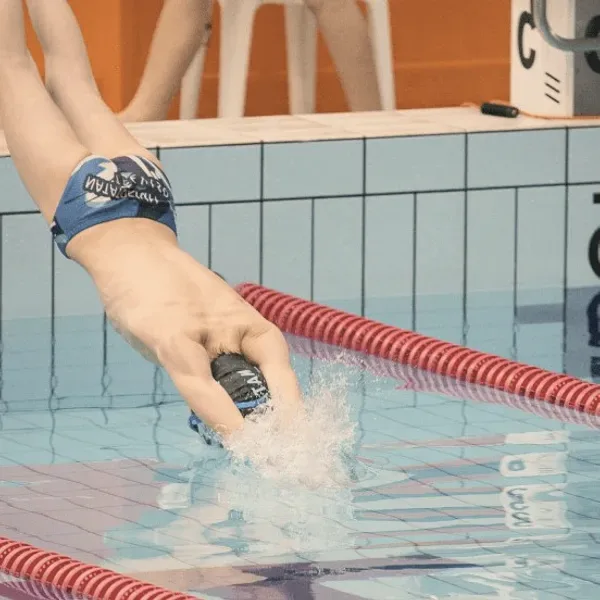A swimmer diving into a pool lane.