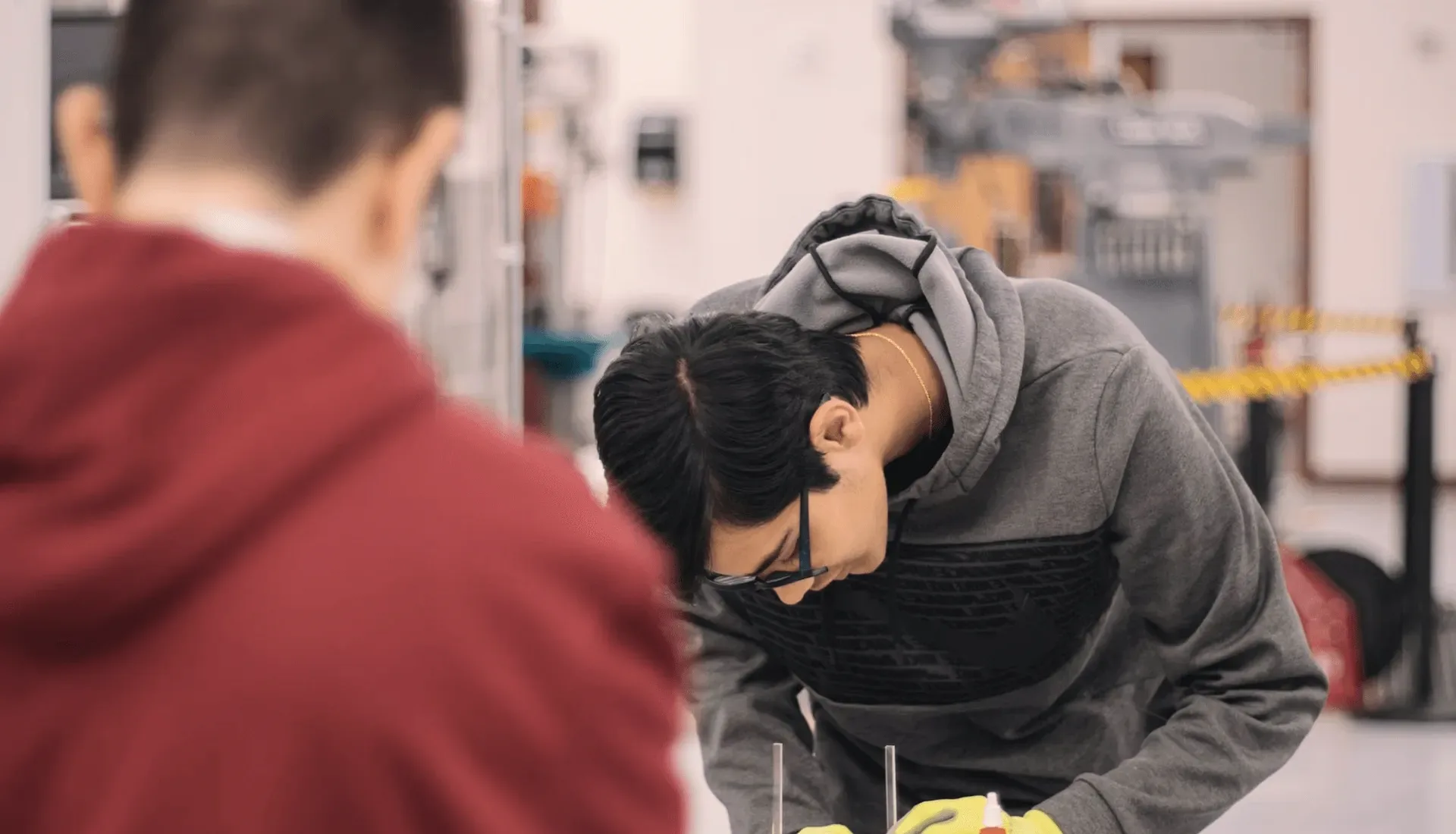 A student bent over a workshop bench.