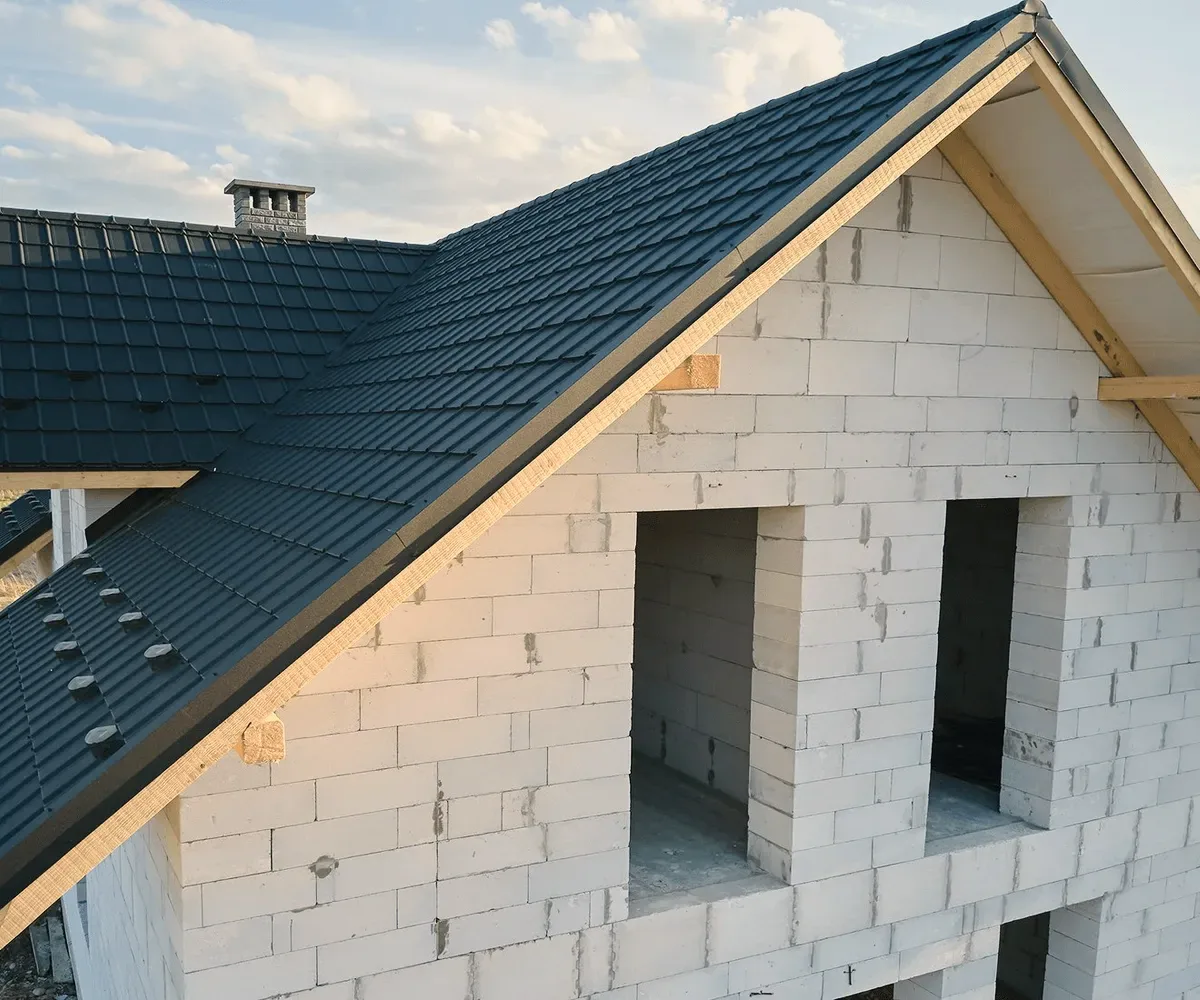 A dark metal roof on a block house.