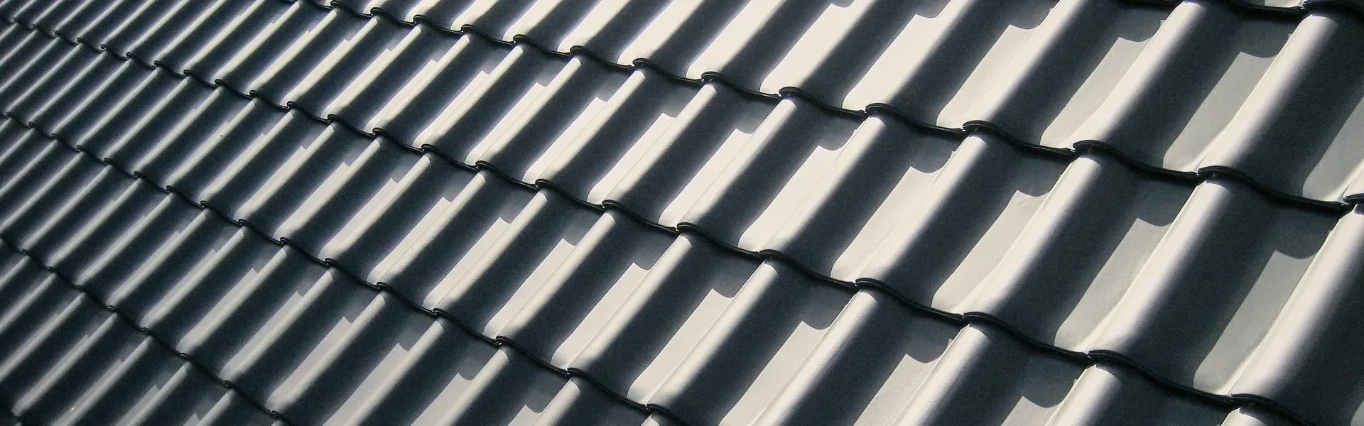 Dark tiles on a roof, close.
