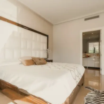 A bright bedroom with a tufted headboard and white linen.