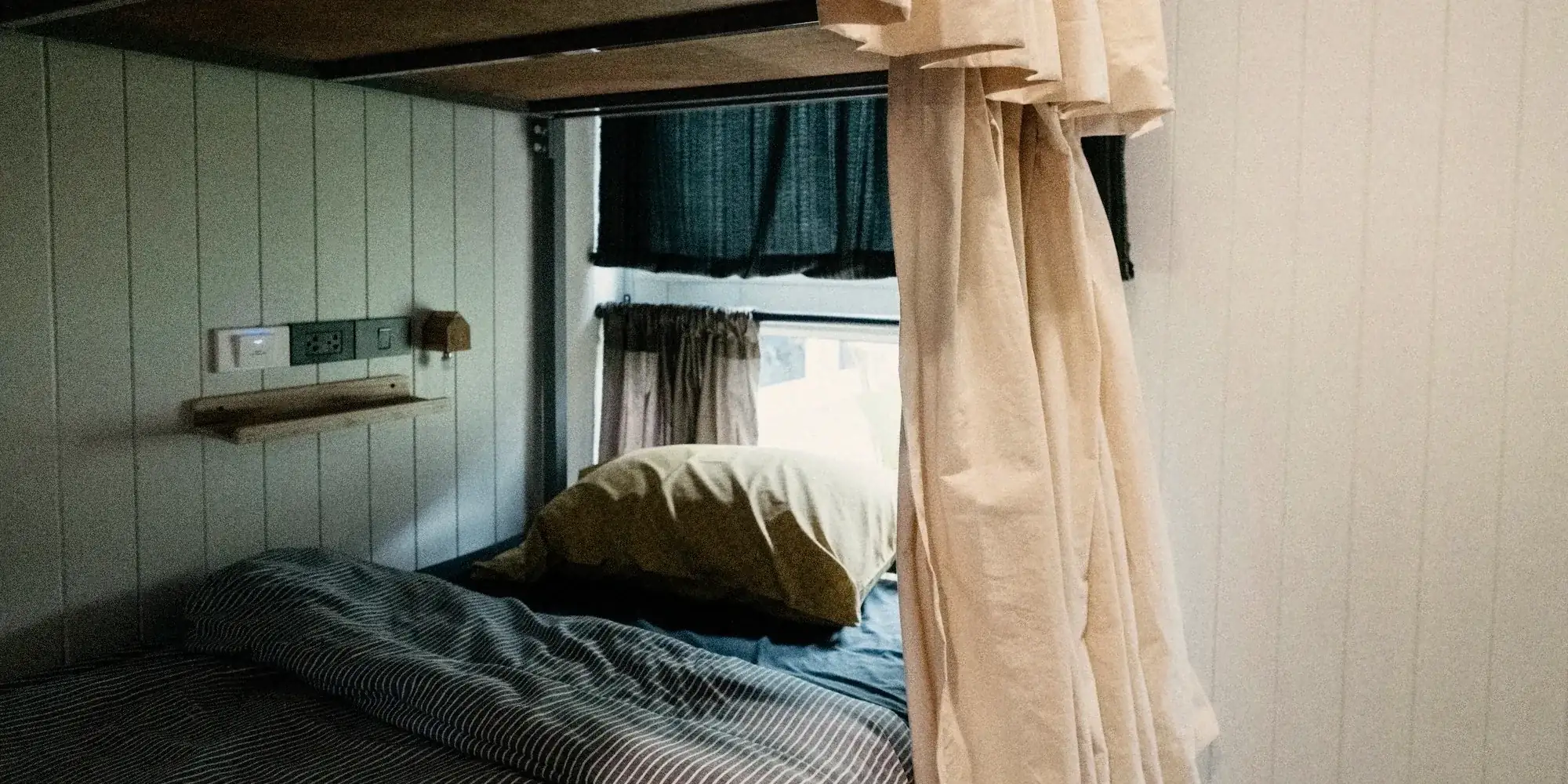 A curtained bunk with its own shelf and light.