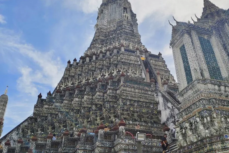 The towers of Wat Arun against a blue sky.