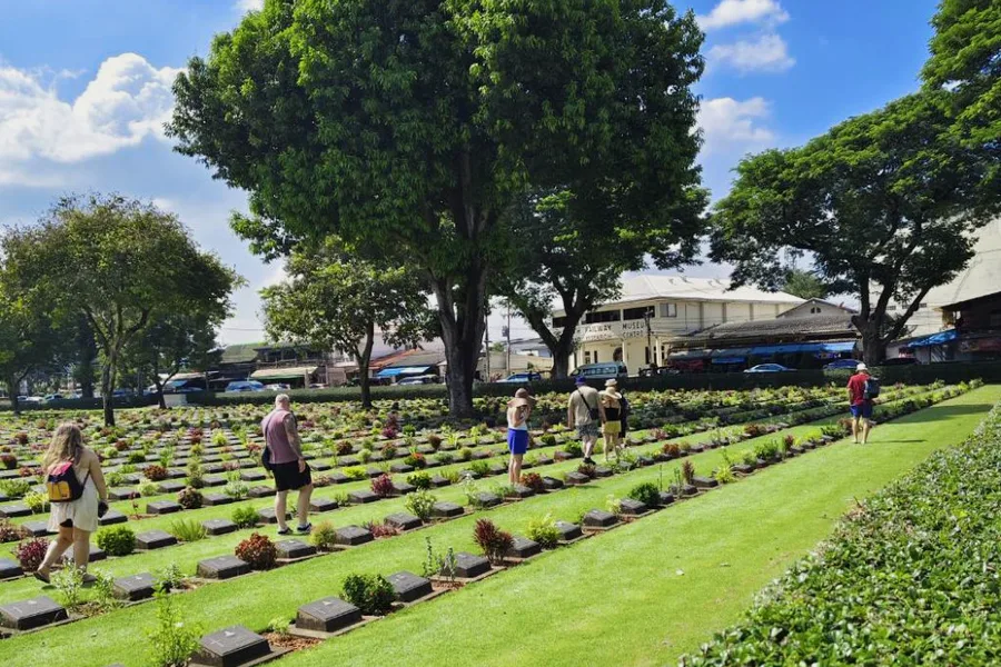 Visitors walking between the rows of a war cemetery.