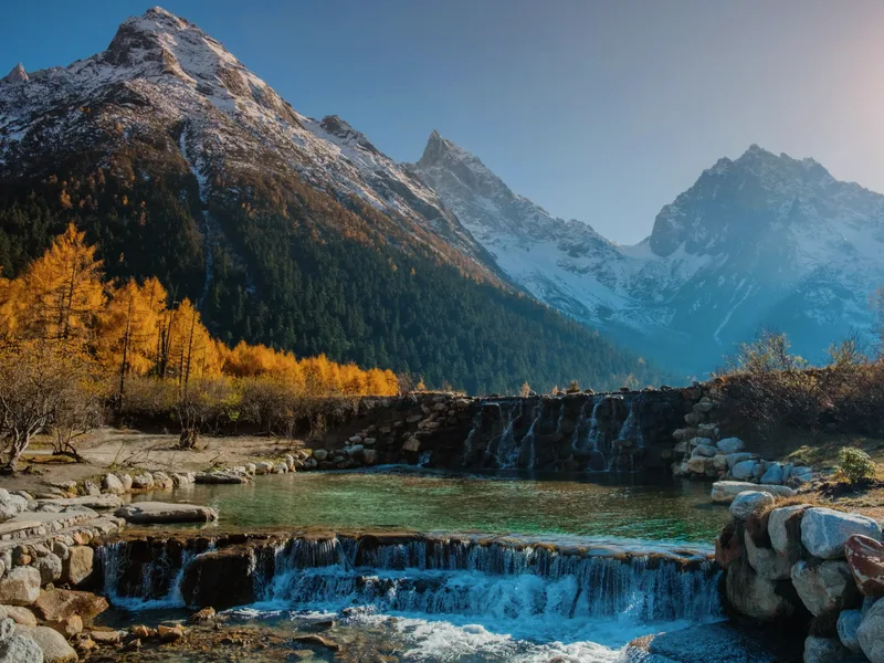 A mountain valley in Sichuan in autumn, with a waterfall.