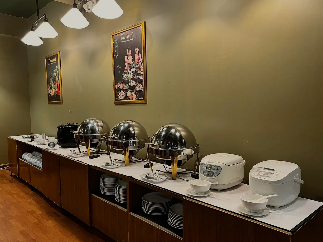 The breakfast counter with steel warmers and rice cookers.