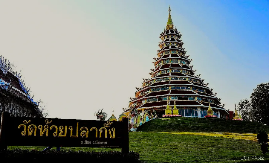 The nine-tiered white pagoda of Wat Huay Pla Kang under a pale sky.