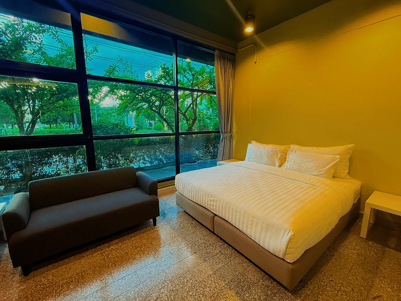 The deluxe room's sofa in front of a window wall onto the garden.