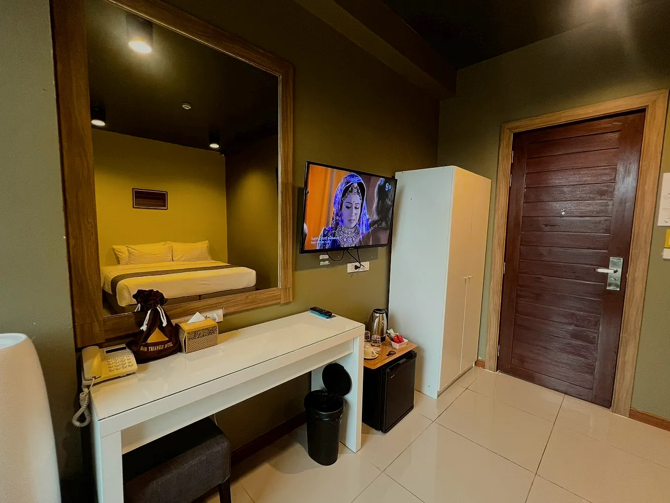 The superior room from the door: the bed, a mirror and the TV.