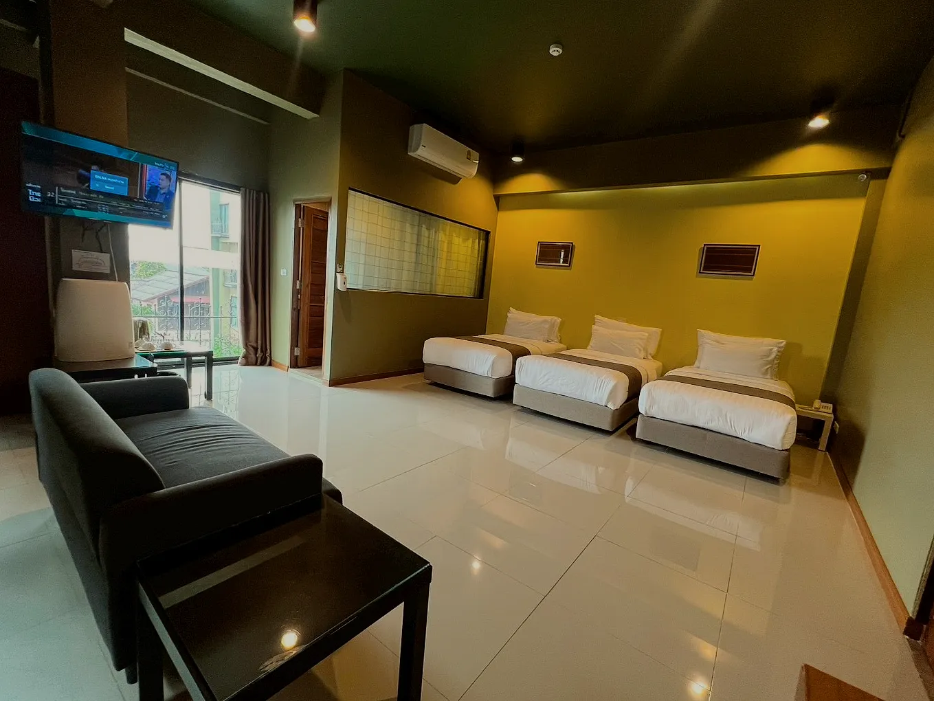 The triple room's lounge corner: a dark sofa and a coffee table.
