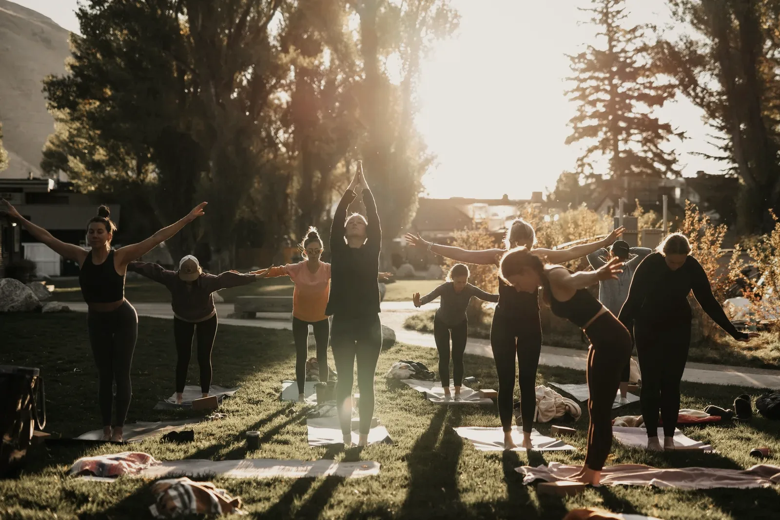A group practising outdoors on a lawn at golden hour.