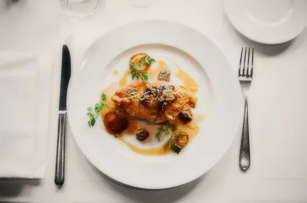 Grilled chicken on a plate with cutlery.