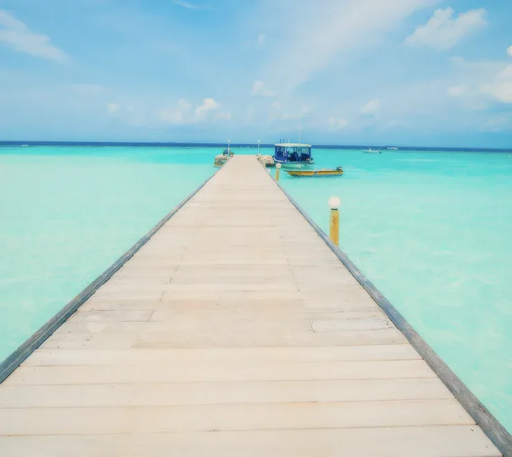 A wooden pier over clear turquoise water.